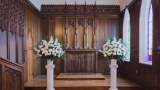 Image of a two flower bouquets in a church.